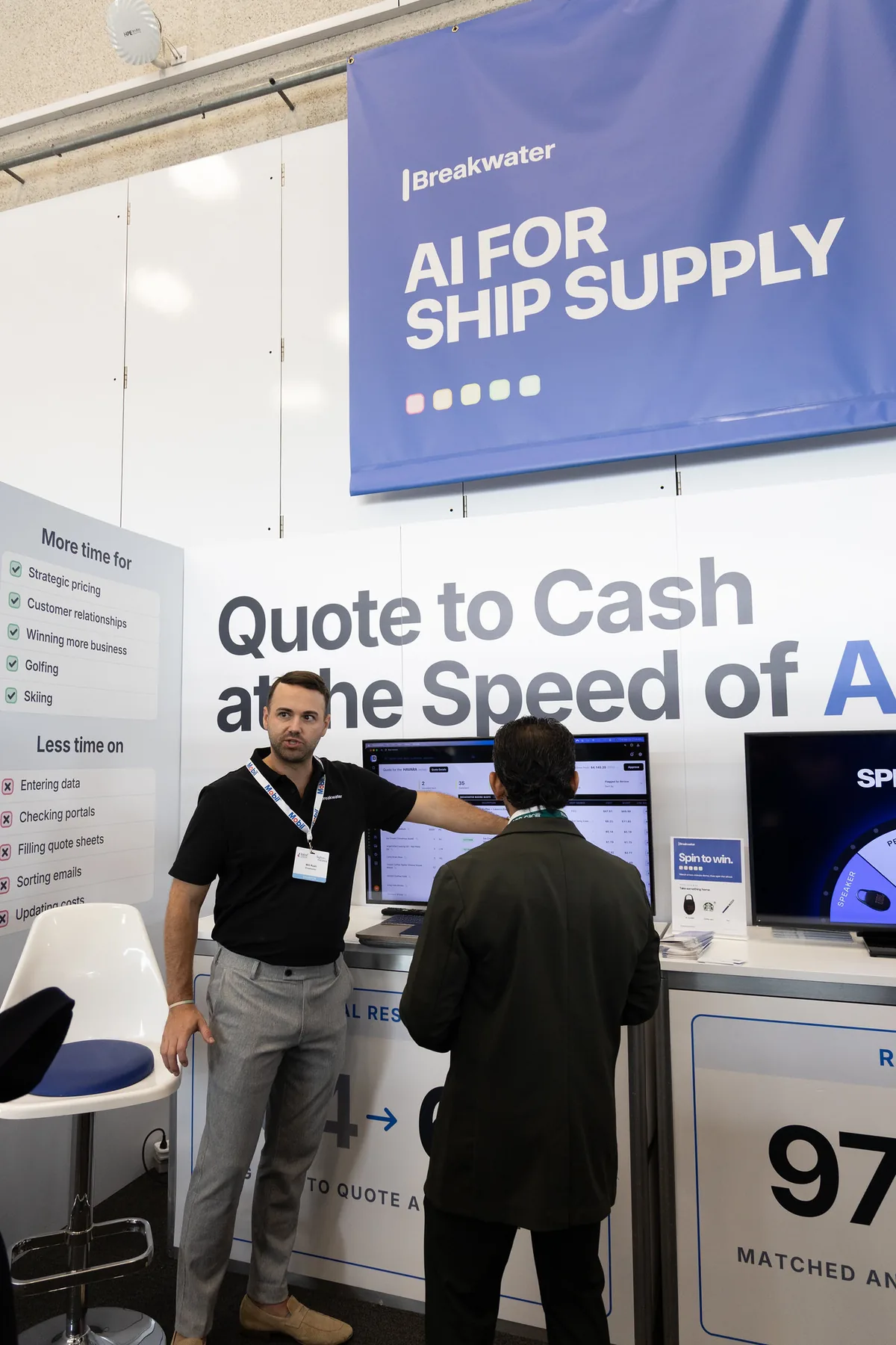 Will Rush pointing at a Blue Horizon quote on a screen while a visitor watches at the Breakwater booth at IMPA London 2026
